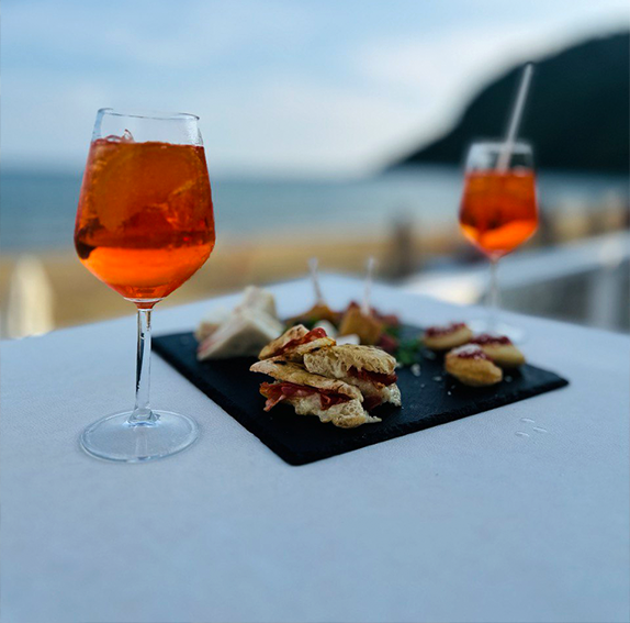 stuzzicherie che accompagnano l'aperitivo in primo piano sul mare di Terracina