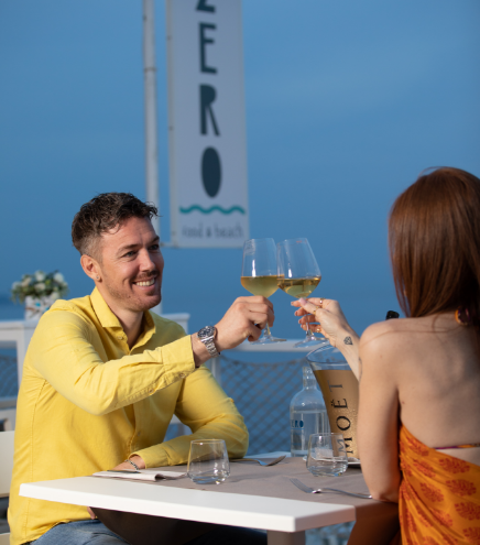 couple toasting with raised glasses